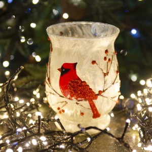 Χριστουγεννιάτικη σύνθεση κόκκινου καρδηνάλιου με γυάλινη μπάλα και κηροπήγιο